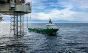 Supply vessel approaching offshore oil platform in Danish waters, showcasing maritime industry.