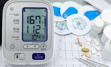 A close-up shot of medical equipment including blood pressure monitor and pills on an ECG graph.