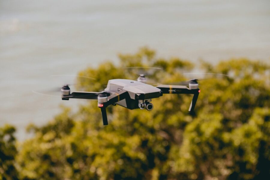 Aerial view of a drone flying over lush greenery and water, capturing stunning outdoor scenes.