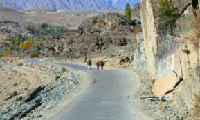 Explorers on a winding road in the rugged Gilgit-Baltistan landscape.