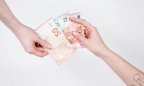 Close-up of hands exchanging euro banknotes, symbolizing financial transactions and currency exchange.