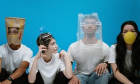 Four people wearing humorous DIY face masks against a blue background, showcasing creativity and humor.
