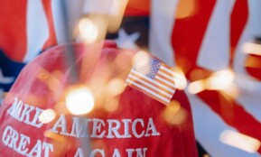 Close-up of a red cap with 'Make America Great Again' and a small American flag.
