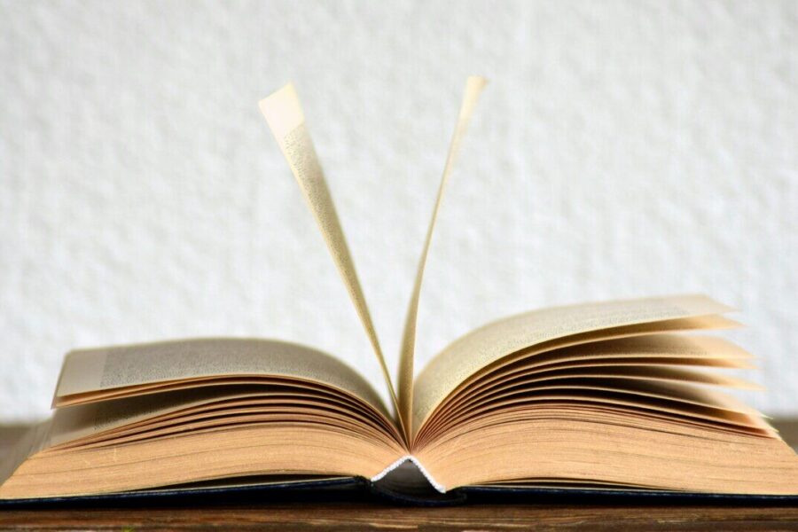 Close-up image of an open book with pages turning, creating a dynamic visual.