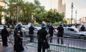 Law enforcement officers manage traffic and crowd control in urban city setting.
