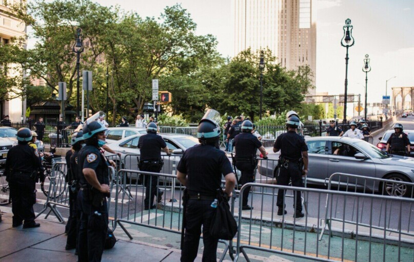 Law enforcement officers manage traffic and crowd control in urban city setting.