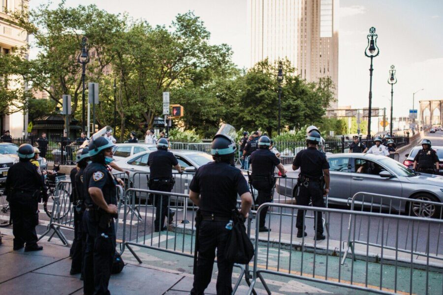 Law enforcement officers manage traffic and crowd control in urban city setting.