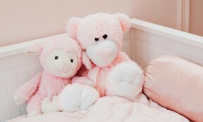 Cute pink plush toys on a bed in a children's room, exuding comfort and innocence.