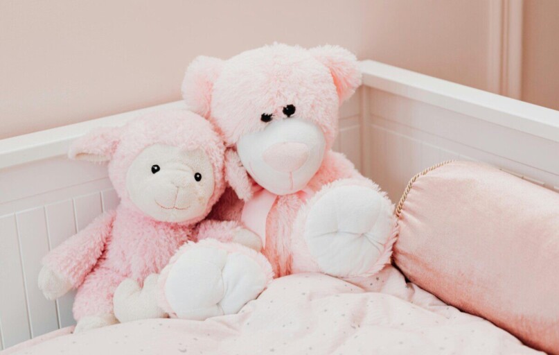 Cute pink plush toys on a bed in a children's room, exuding comfort and innocence.