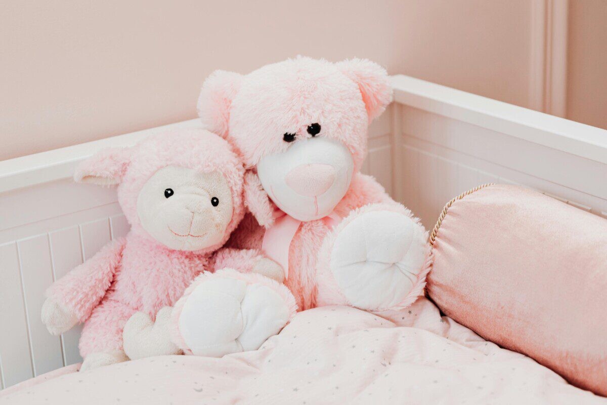Cute pink plush toys on a bed in a children's room, exuding comfort and innocence.