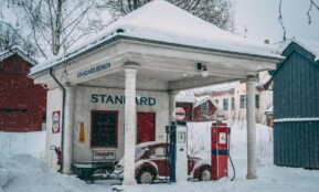 A vintage gas station covered in snow during a winter day in Oslo, Norway.