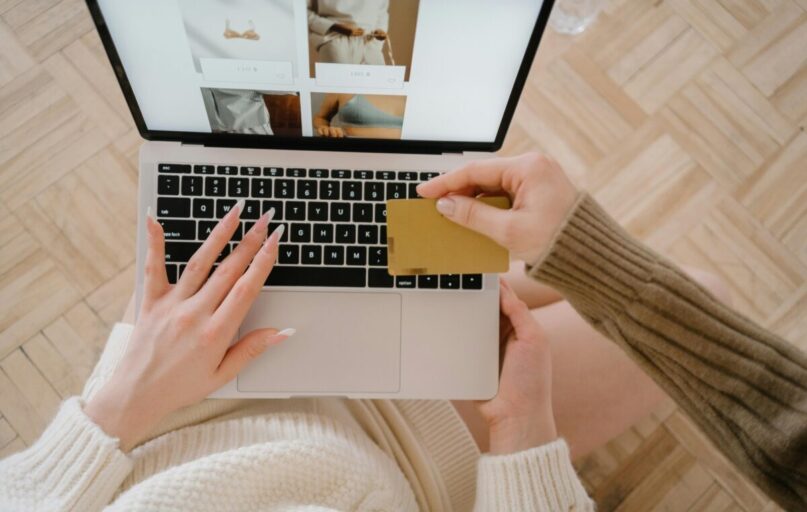 Person shopping online using a laptop and credit card, highlighting e-commerce convenience.