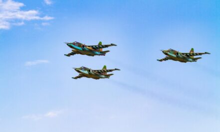 Sukhoi Su-25 aircrafts flying in perfect formation against a clear blue sky.
