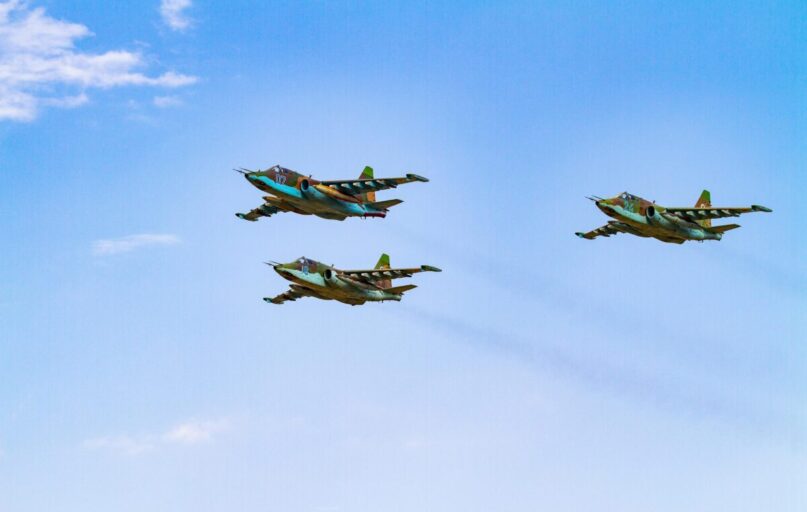 Sukhoi Su-25 aircrafts flying in perfect formation against a clear blue sky.