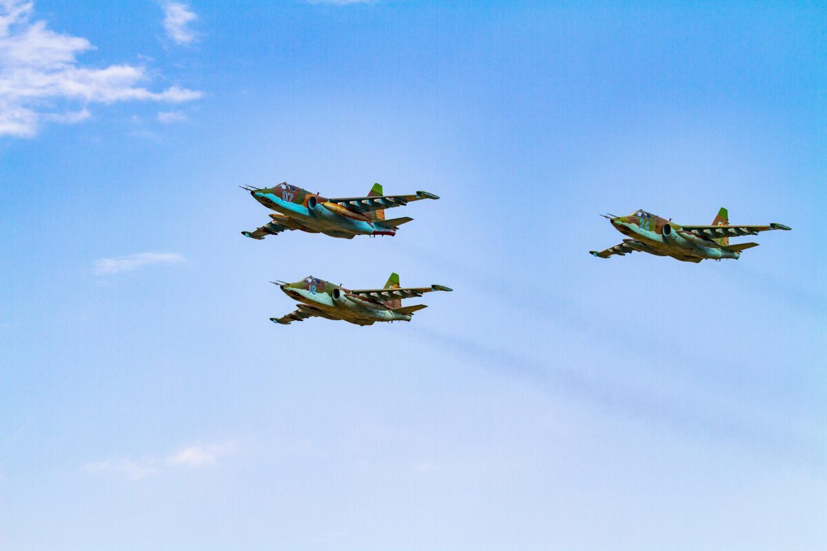 Sukhoi Su-25 aircrafts flying in perfect formation against a clear blue sky.