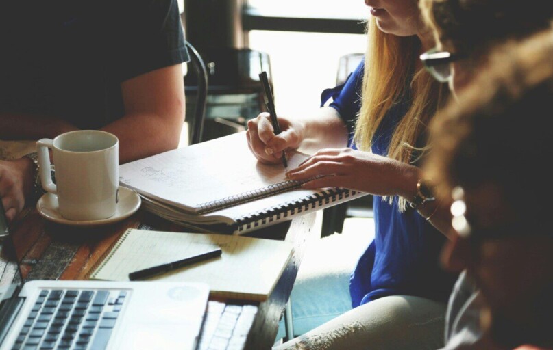 A group of young adults working together on a project at a casual meeting.