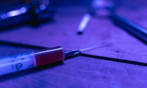 A close-up of a syringe with a dark and moody tone, symbolizing addiction and treatment.