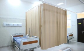 Quiet hospital ward with beds and privacy curtains in Surabaya, Indonesia.