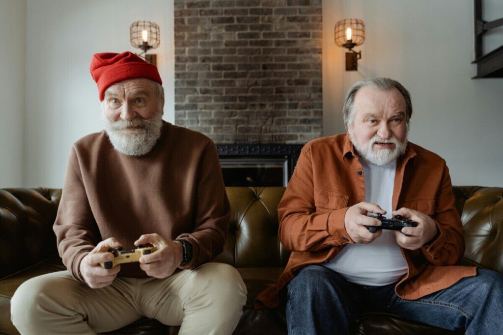 Elderly men with gray hair play video games, embracing leisure and hobbies indoors.