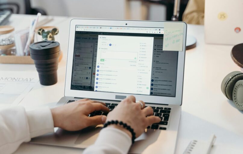 A person typing on a laptop in a bright, modern office setting, showing productivity and technology.