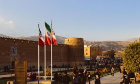 Karim Khan Citadel with Iranian flags in Shiraz, Iran at sunset.