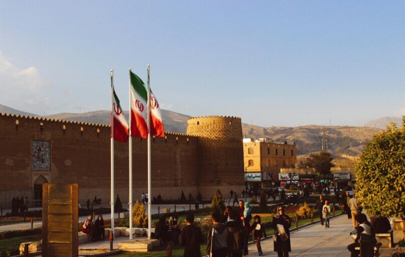 Karim Khan Citadel with Iranian flags in Shiraz, Iran at sunset.