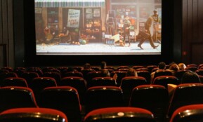 A cozy indoor movie theater showing an animated film to a small audience.