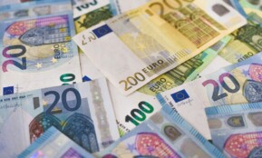 Close-up of various Euro banknotes scattered on a surface, highlighting European currency.