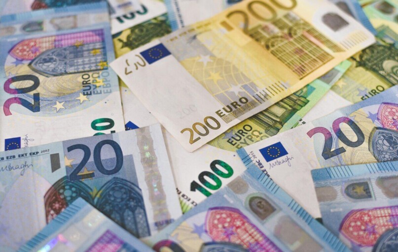 Close-up of various Euro banknotes scattered on a surface, highlighting European currency.
