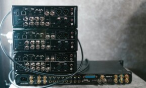 Stacked professional audio video equipment with multiple connectors for recording studio settings.
