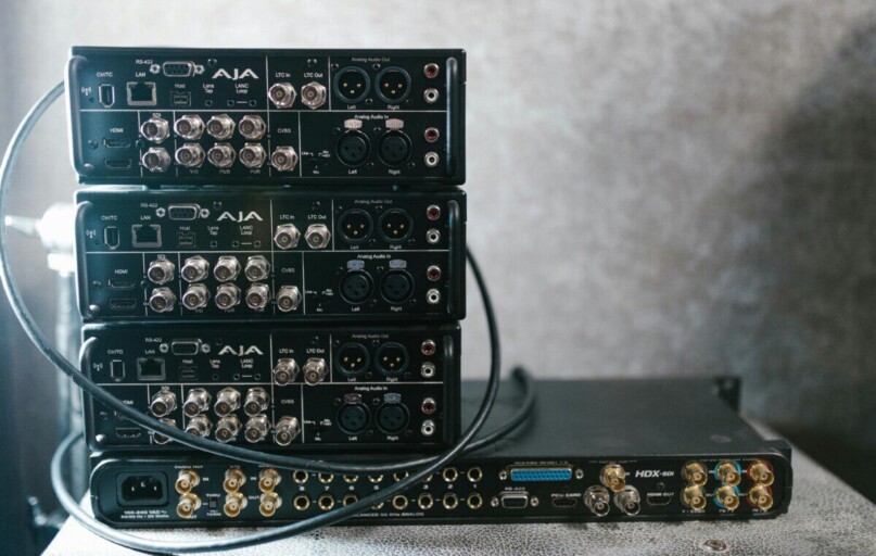 Stacked professional audio video equipment with multiple connectors for recording studio settings.