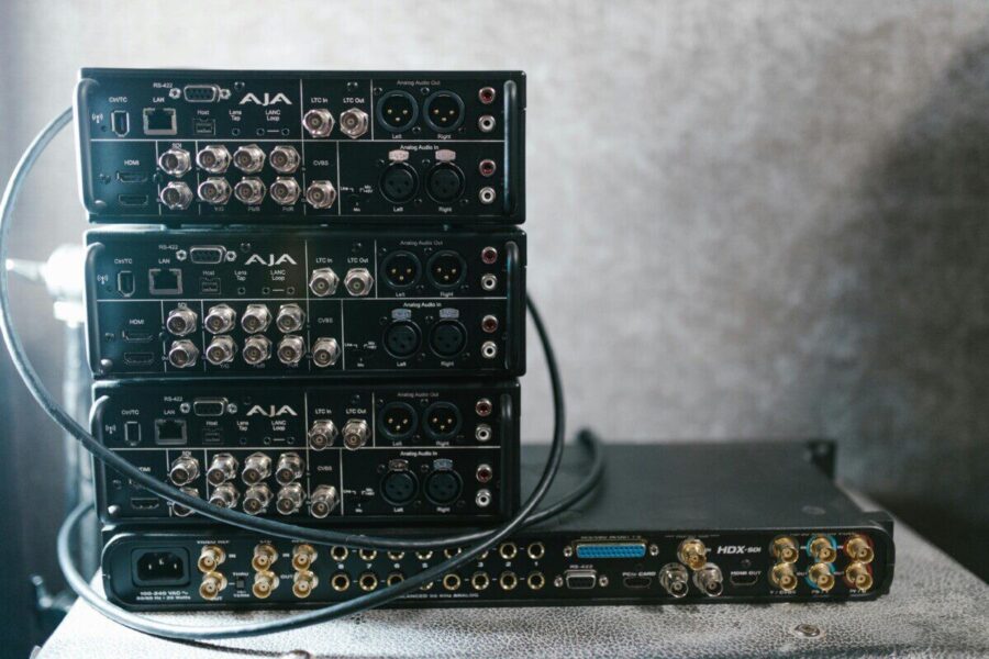 Stacked professional audio video equipment with multiple connectors for recording studio settings.