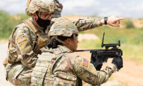 Two US soldiers engage in outdoor combat training, focusing on weapon proficiency.