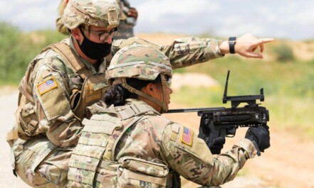 Two US soldiers engage in outdoor combat training, focusing on weapon proficiency.