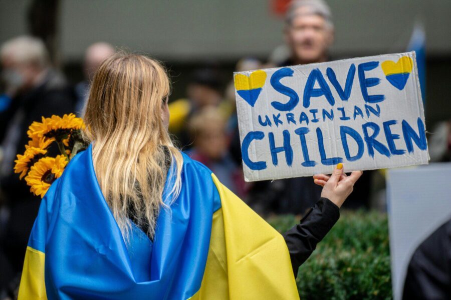 A peaceful protestor holds a 'Save Ukrainian Children' sign in New York City.