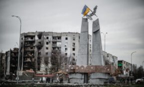 A monument stands beside war-torn buildings in Borodyanka, Ukraine.