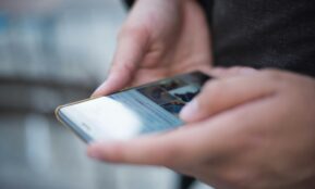 Close-up of hands using a smartphone with a touchscreen, emphasizing mobile technology.