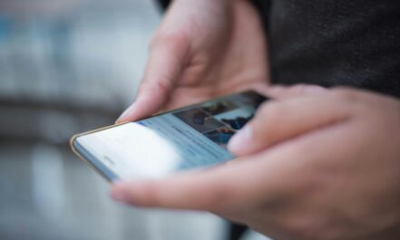 Close-up of hands using a smartphone with a touchscreen, emphasizing mobile technology.