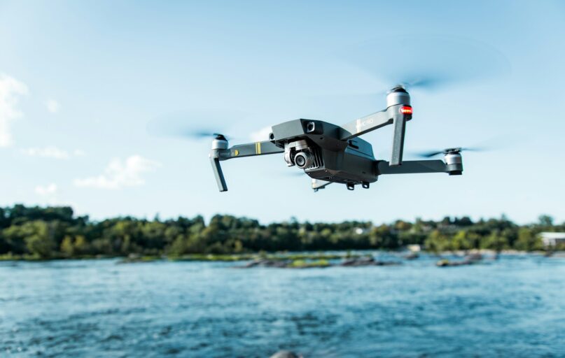 black DJI Mavi quadcopter near body of water