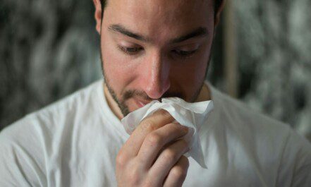 man wiping mouse with tissue paper
