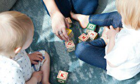 two toddler playing letter cubes