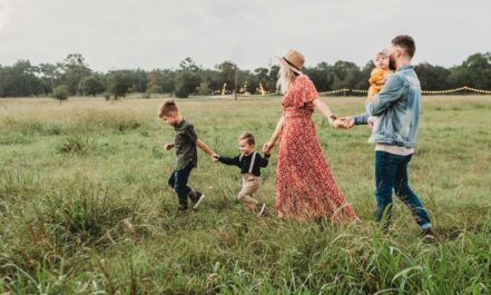 woman holding man and toddler hands during daytime