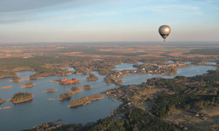 a hot air balloon flying over a large body of water