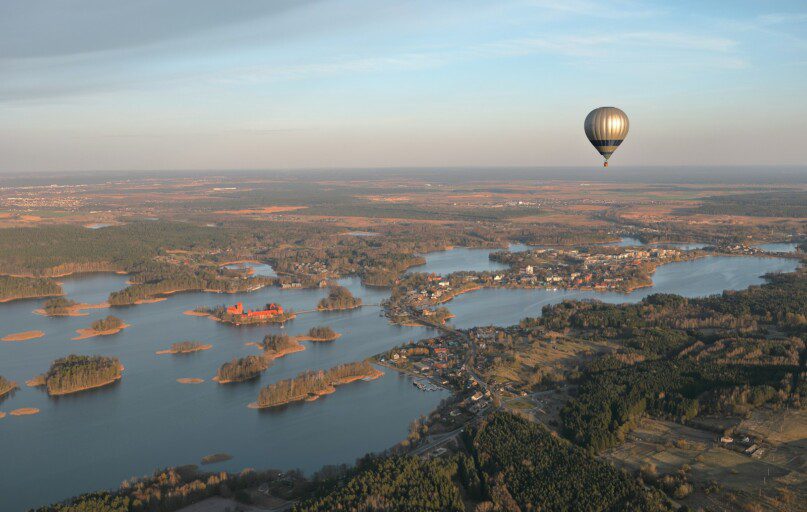 a hot air balloon flying over a large body of water