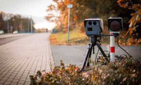 black and gray camera on tripod on road during daytime