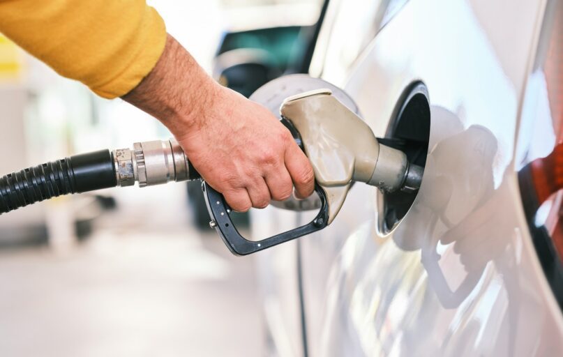 a man pumping gas into his car at a gas station
