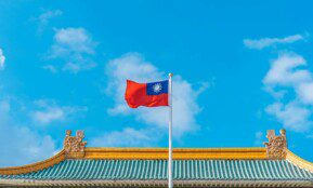 a red and blue flag on top of a building