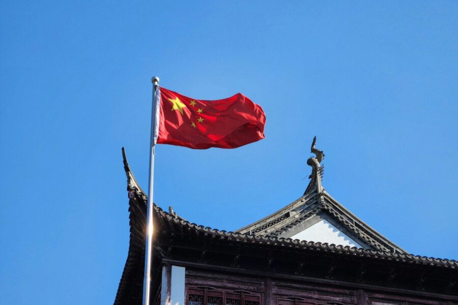 A chinese flag flying on top of a building