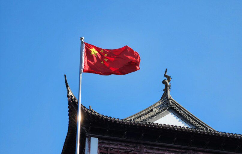 A chinese flag flying on top of a building