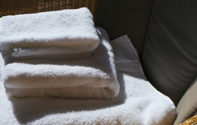 Stack of clean white towels on a surface.